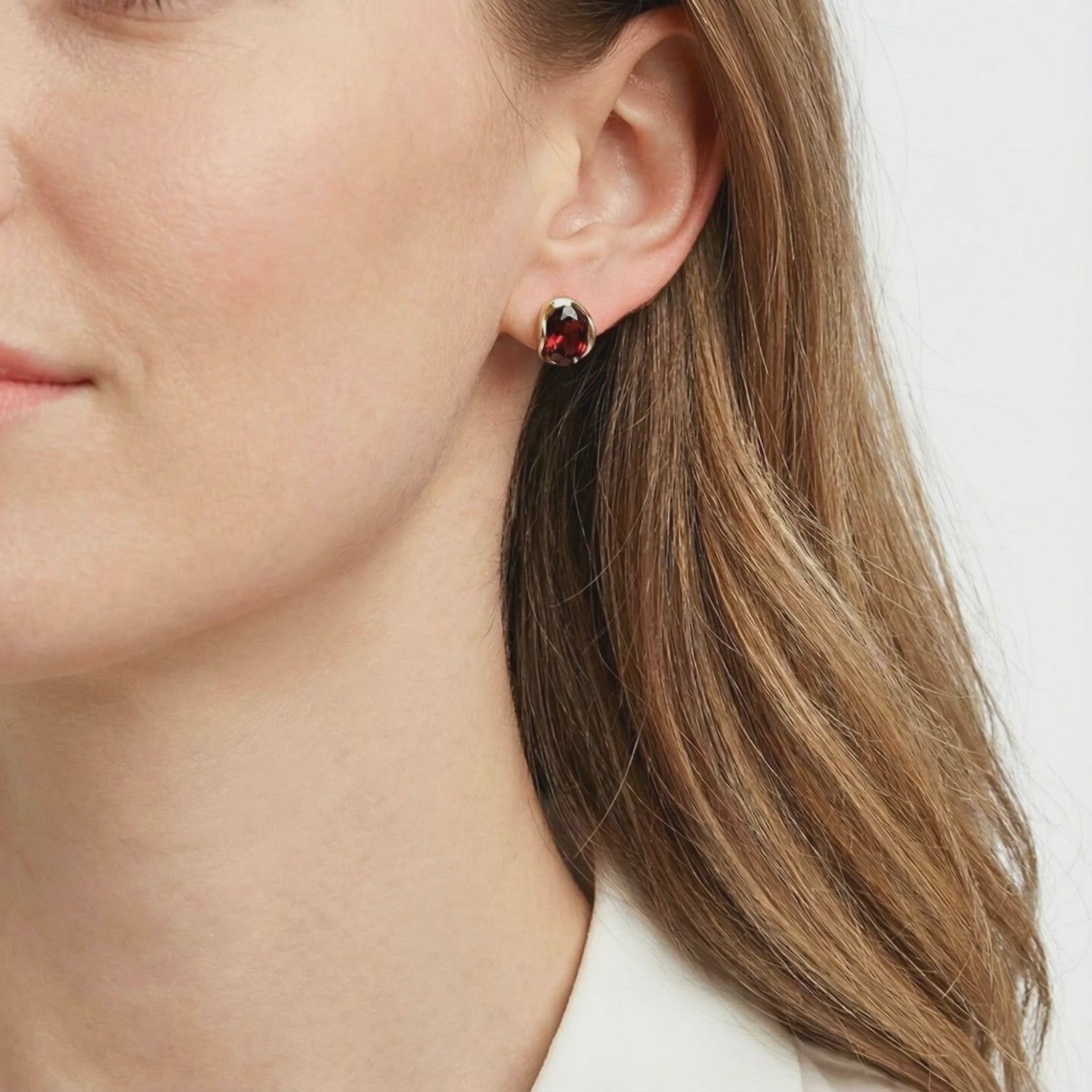 Solid gold huggie earrings with simulated garnet.