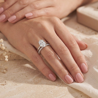 Model wearing the silver ring set featuring a large oval gem and a slender pavé band.