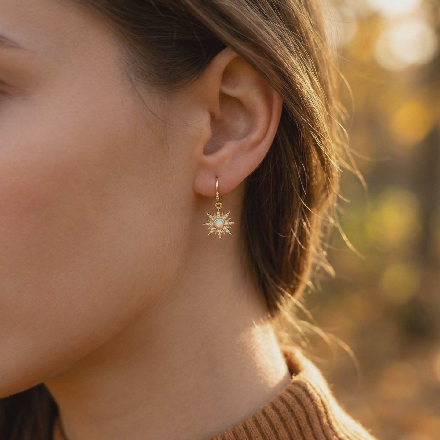Solid gold opal starburst drop earrings.