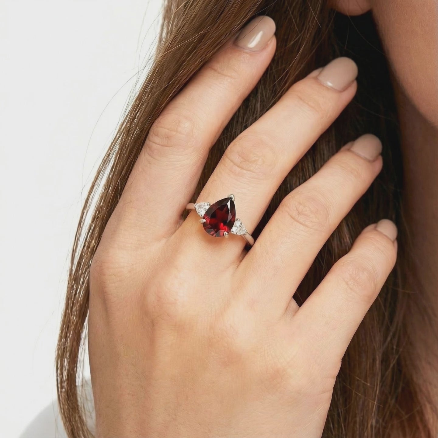 A solid gold ring with a pear-shaped simulated garnet.